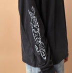 Black long-sleeve shirt with white text design on a beige background