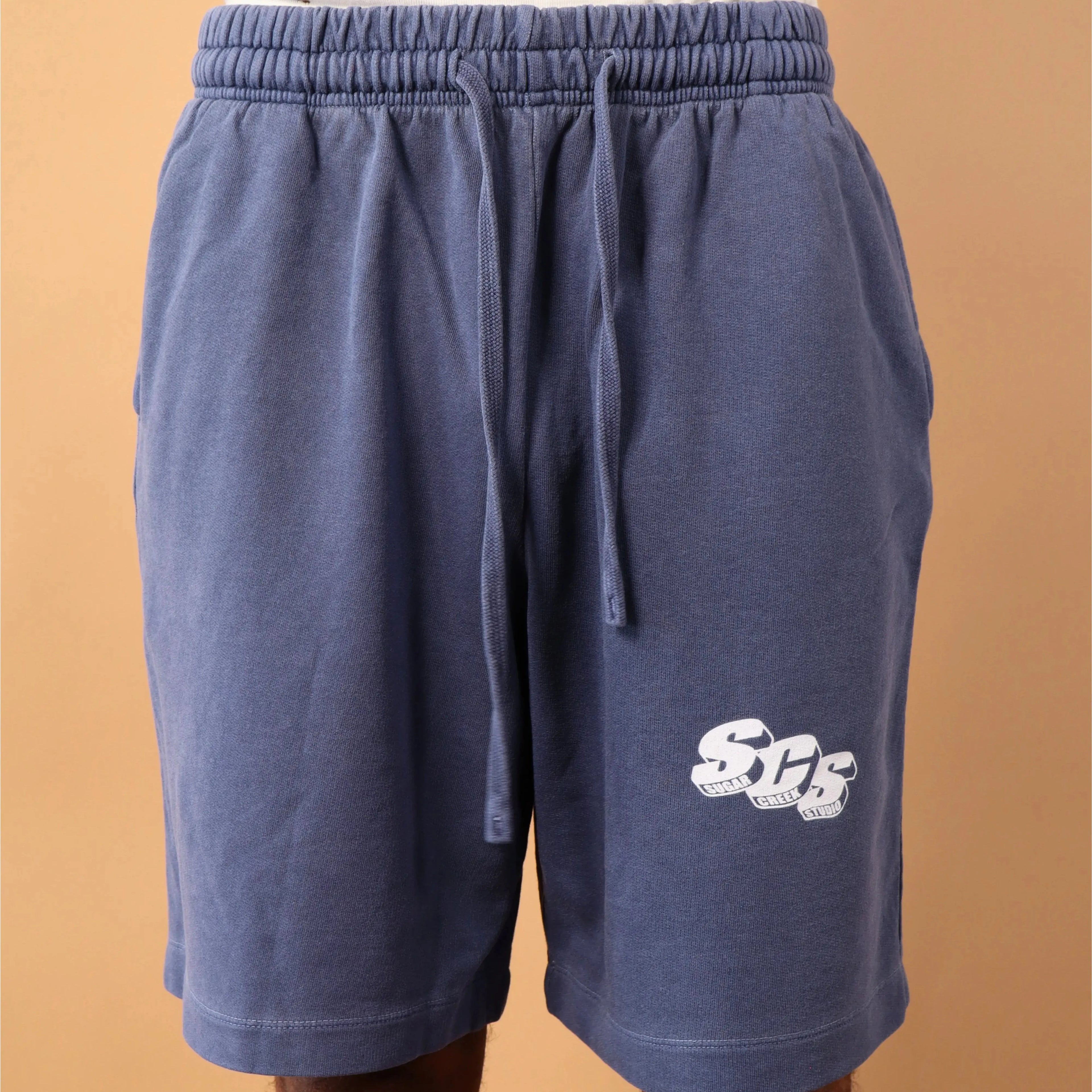 Blue shorts with a logo on a beige background
