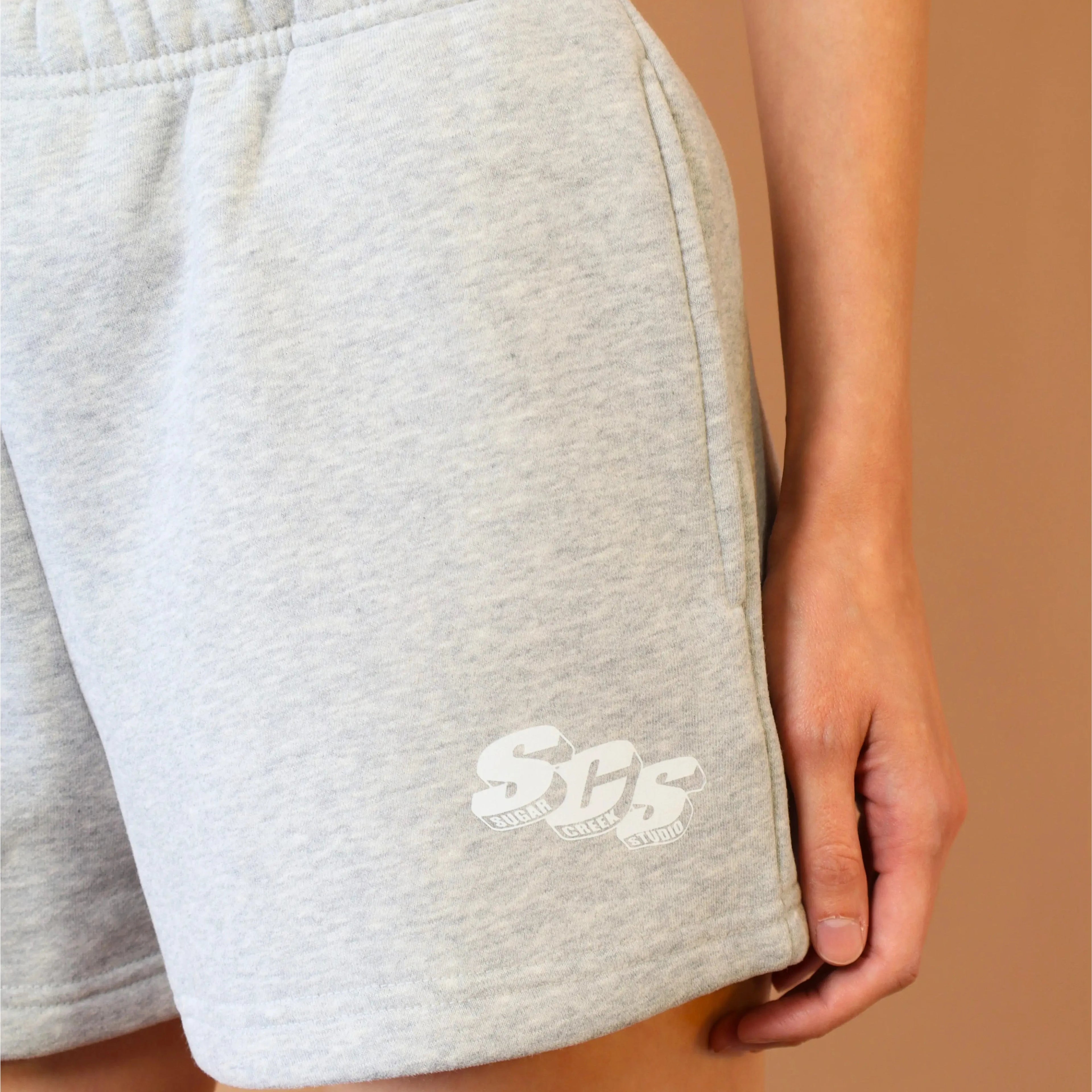 Gray shorts with a logo on a beige background